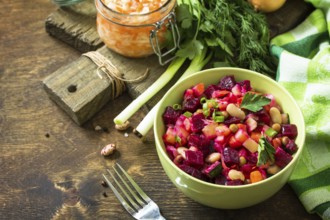 Beetroot salad vinaigrette with sauerkraut, pickled cucumber and vegetables on a wooden rustic