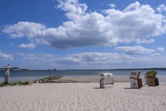 A quiet beach with beach chairs and a sculpture at the water's edge, Eckernförde,