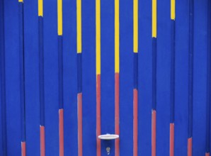 Garage door with graphic pattern in the colours blue, red and yellow, format-filling