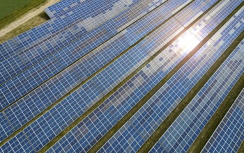 Solar panel field at work with sun reflection