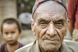 Damak, Nepal, circa May 2012: Old frowning man with beard and wrinkles on his face at Nepali