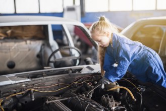 Little girl repairing car with spanner