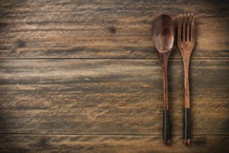 Wooden spoon and fork on rustic wooden table with copy space for your text