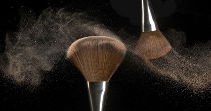 Make-up Brush spreading blush powder on black background