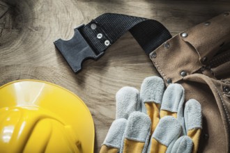 Leather belt Safety gloves Safety helmet on wooden board