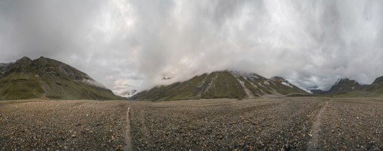 Panoramic view of hiking trail in glacial valley high up in Kashmir mountains in India on cloudy
