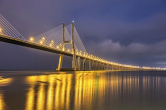 The famous Vasco da Gama cable-stayed bridge over the River Tagus in Lisbon, Portugal, by night