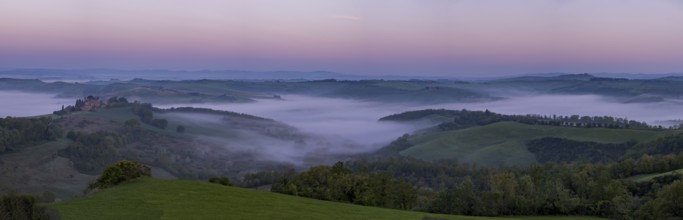 Sunrise with foggy atmosphere in hilly landscape, province of Siena, Tuscany, Italy