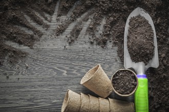 Peat pots soil shovel on wooden board