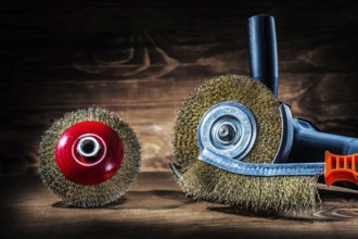 Angle grinder with wire grinding discs and hand wire brush on old wood