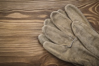 Brown protective gloves on vintage wooden board Construction concept