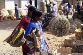 A woman checking the bamboo basket quality for purchasing at Thudiyalur, Coimbatore, Tamil Nadu,