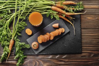 Top view at fresh organic vegetarian carrot juice on wooden kitchen table