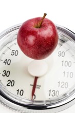 An apple lies on a bathroom scales. Symbolic photo for weight loss and a healthy, vitamin-rich diet