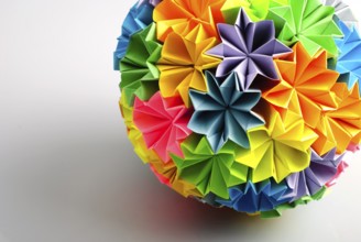Colorfull origami kusudama from rainbow flowers isolated on white. Close-up with shadow