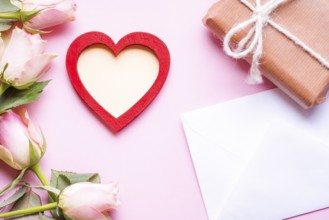 Valentine day theme image with a red heart with copy space in the middle, surrounded by pink roses,
