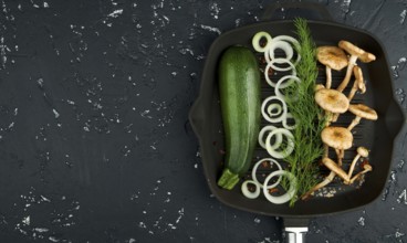 Fresh mushrooms with spices and herbs on black board. View from above. Copy space