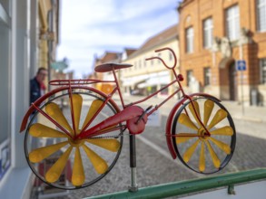 Colourfully painted small tin bicycle in front of a shop, Tangermünde, Saxony-Anhalt, Germany