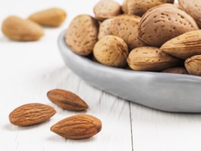 Almond on white wooden background