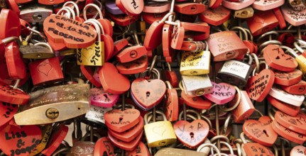 Verona, Italy, June 2022: background of heart-shaped locks on a wall, symbol of love forever