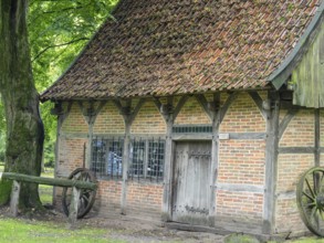 Old half-timbered house with tiled roof, surrounded by trees and nature, Bad Zwischenahn,
