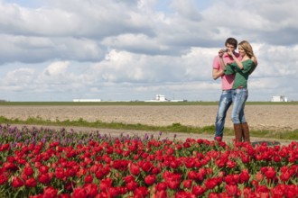 Young couple is taking pictures in Holland from flower fields