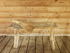 Bench and broom over it against wooden wall