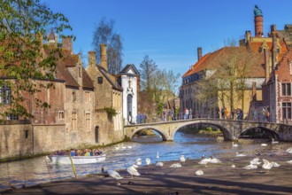Bruges, Belgium, April 10, 2016: Canal and bridge view with tourists in popular belgian