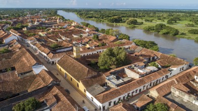 Aerial view of the historic town Santa Cruz de Mompox in sunlight with river and green