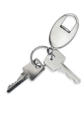 Metal key with trinket over white background
