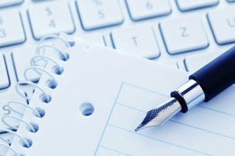 A notepad and the keyboard of a computer. Take notes and save them. Austria