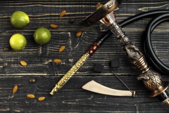 Dismantled parts of hookah on a wooden background with lime fruit. Top view. Flat lay. Copy space.