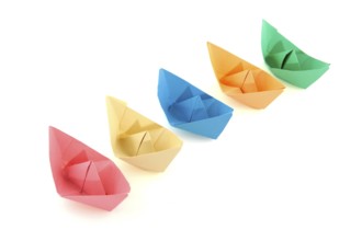Colorful folder paper boats isolated over white