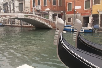 Two gondola in Venice near pier and bridge