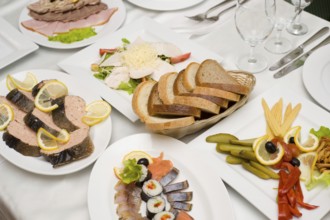 Laid table with tableware and cold snacks for banquet in shallow DOF