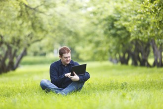 Middle-aged businessman working with notebook in the park