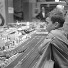 Toys in the 1960s. A boy fascinated by a miniature racing track by Scalextric. You could race cars