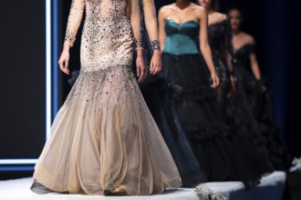 Female models walk the runway in beautiful designer dresses during a Fashion Show. Fashion catwalk