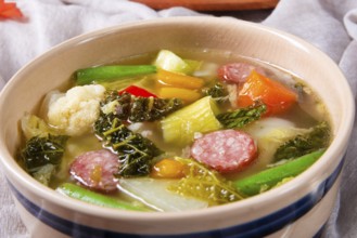 Delicious autumnal vegetable soup with sausage and bacon