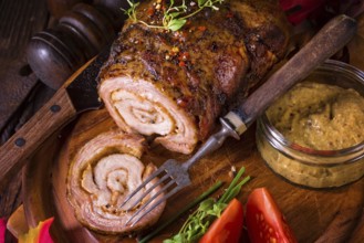 Rolling roasts fullly with dried fruit and bacon
