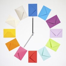 Twelve envelopes isolated on white background. Clock of colored envelopes for Christmas mailing