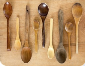 Wooden spoons on a wooden background from above. Studio shot. Kitchen utensil