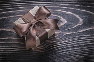 Wrapped gift box on wooden board holidays concept