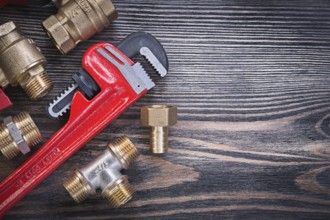 Set of monkey wrench brass connectors on wooden board plumbing concept