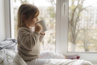 Child drink cocoa or milk near the window from big white mug. mock up of cup. christmas time.