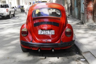 Red Volkswagen Beetle on a city street, Cuba, Greater Antilles, Caribbean, Central America, America