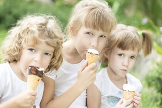 Happy friends eating ice-cream outdoors in spring park