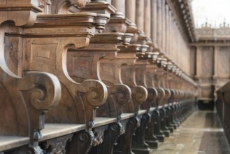 Cathedral choir stalls made of wood. Row of wooden choir stalls