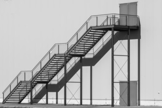 Greyscale shot outdoor stairway to the building in the sun