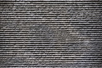 Close-up of a grey clinker brick façade made of rough stones on the façade of a building